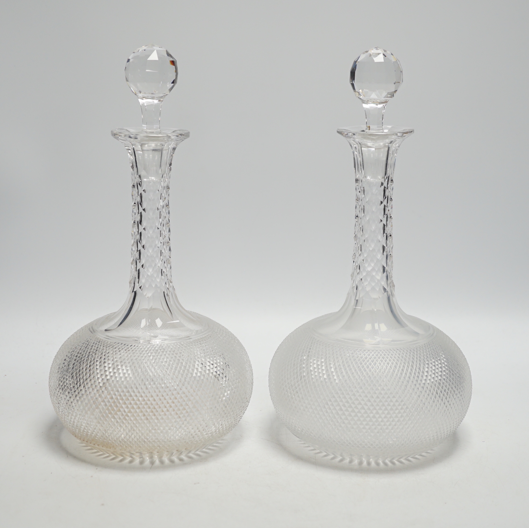 A pair of Victorian 'diamond' cut onion shaped decanters with facet cut stoppers, c.1875